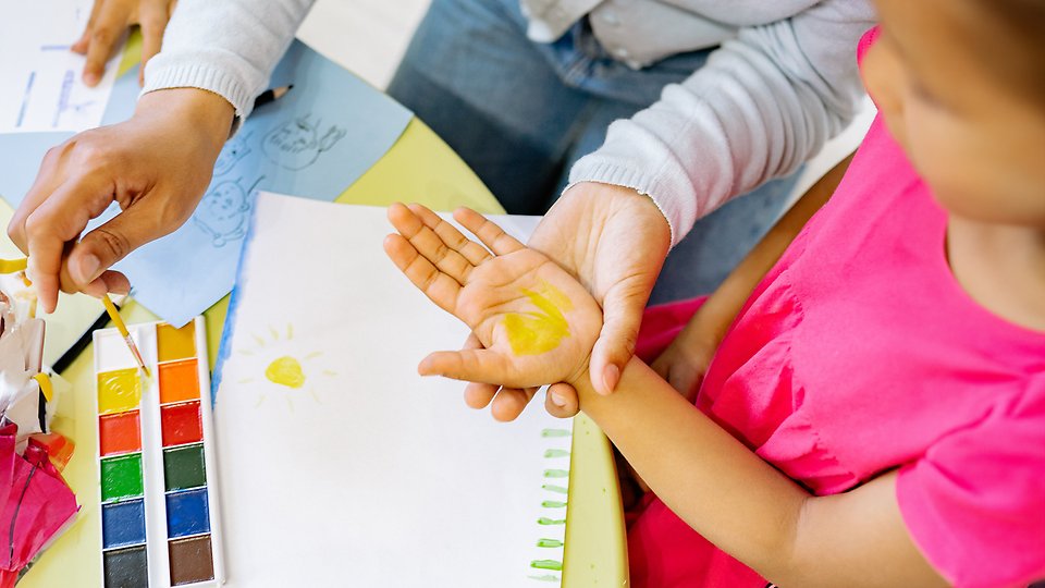 Ett foto på ett barnhand som är målad med färg